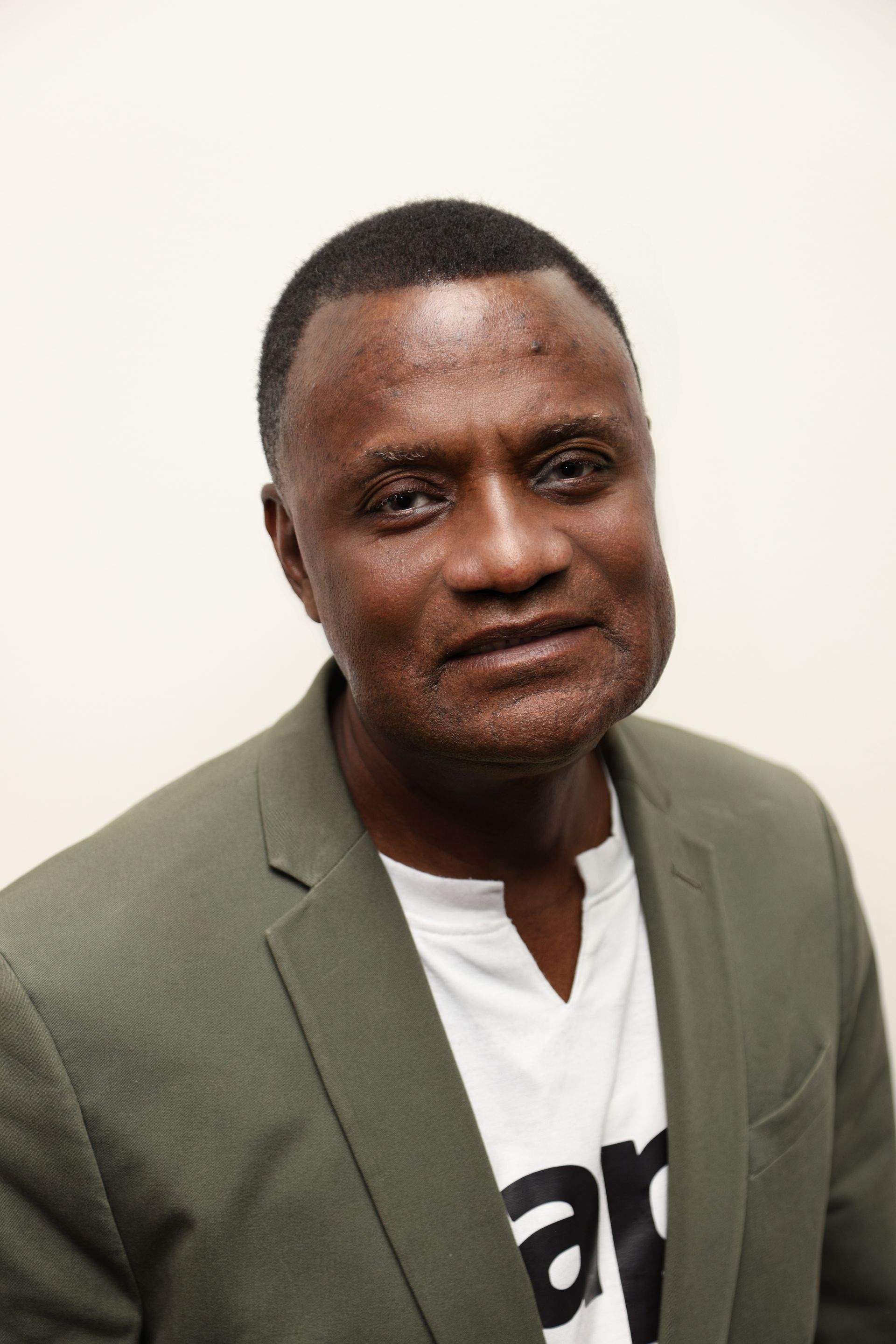 A man in a suit and white shirt is smiling for the camera.