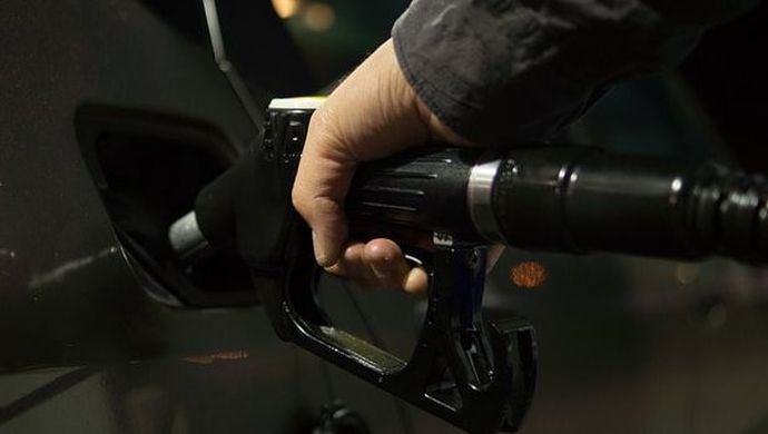 A person is pumping gas into a car at a gas station.