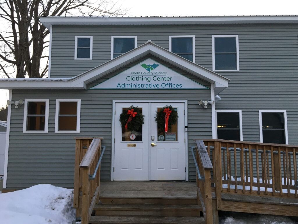 A gray, two-story building with a sign reading