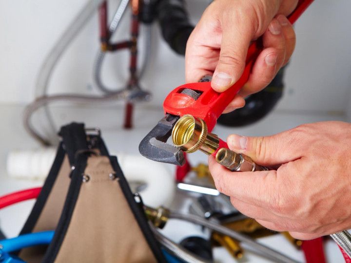Plumber Tightening the Pipes