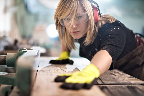 Female carpenter working with machinery in a shop