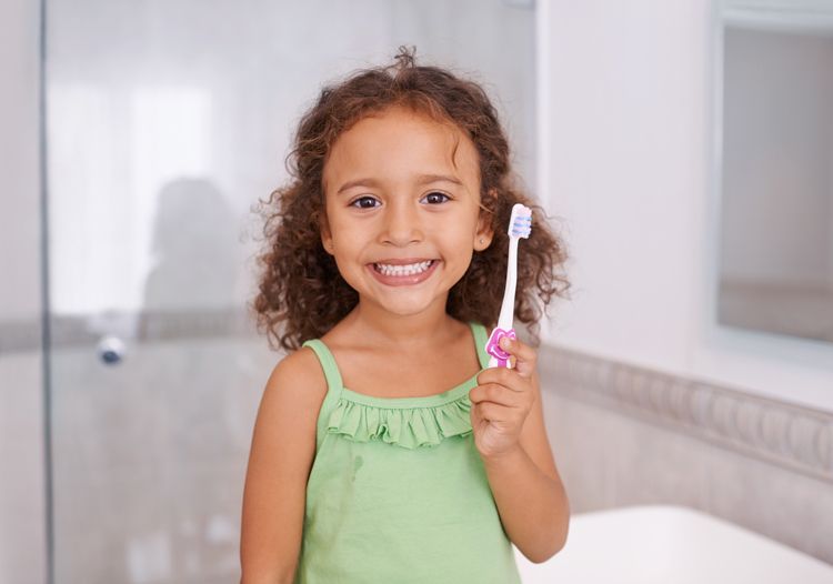 Children Holding A Toothbrush — Leeton, NSW — Leeton Orthodontics