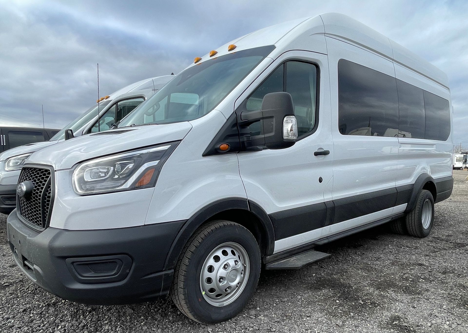 a white van is parked in a gravel lot .