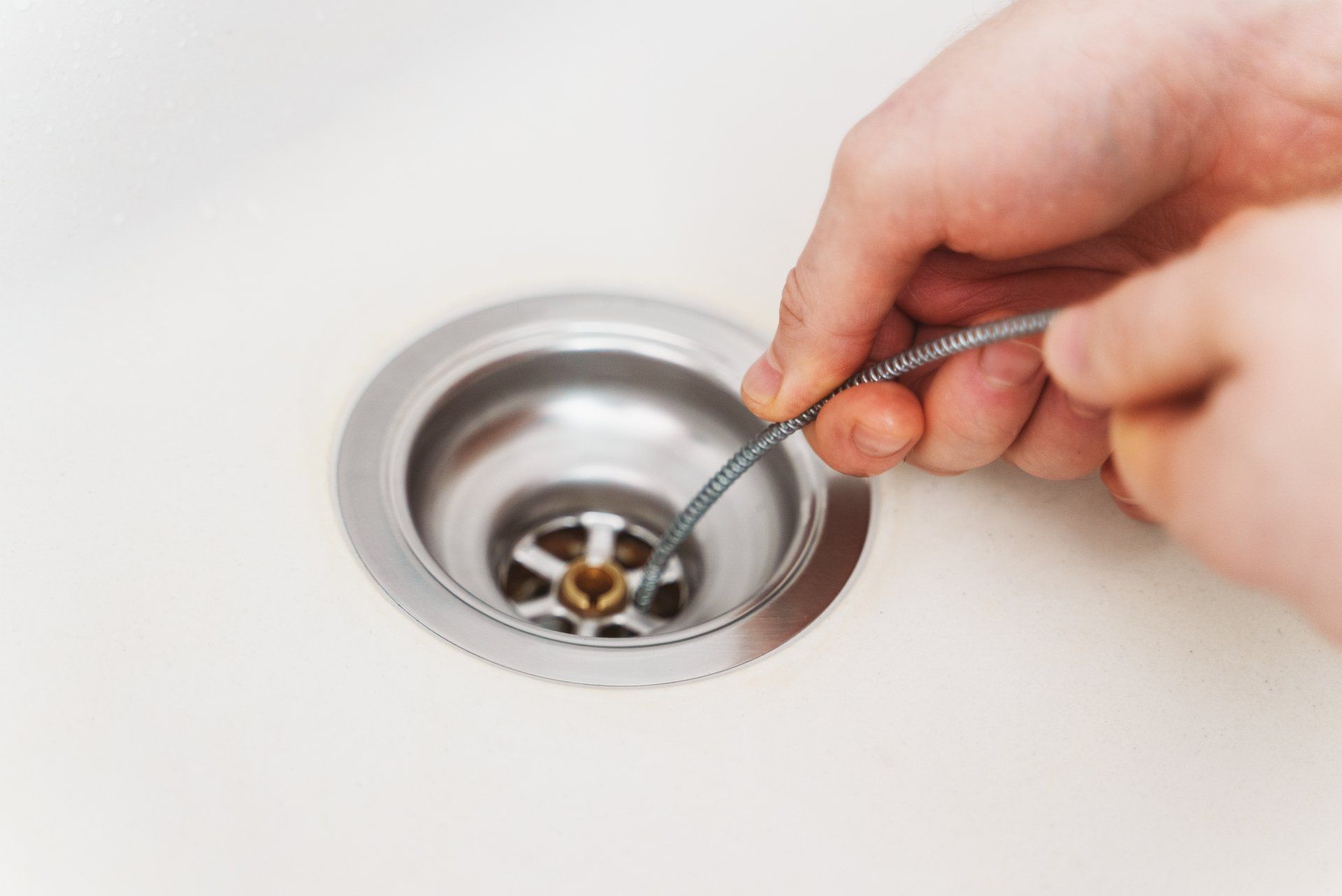 Une personne utilise un nettoyant pour canalisations pour nettoyer le drain d'un évier.
