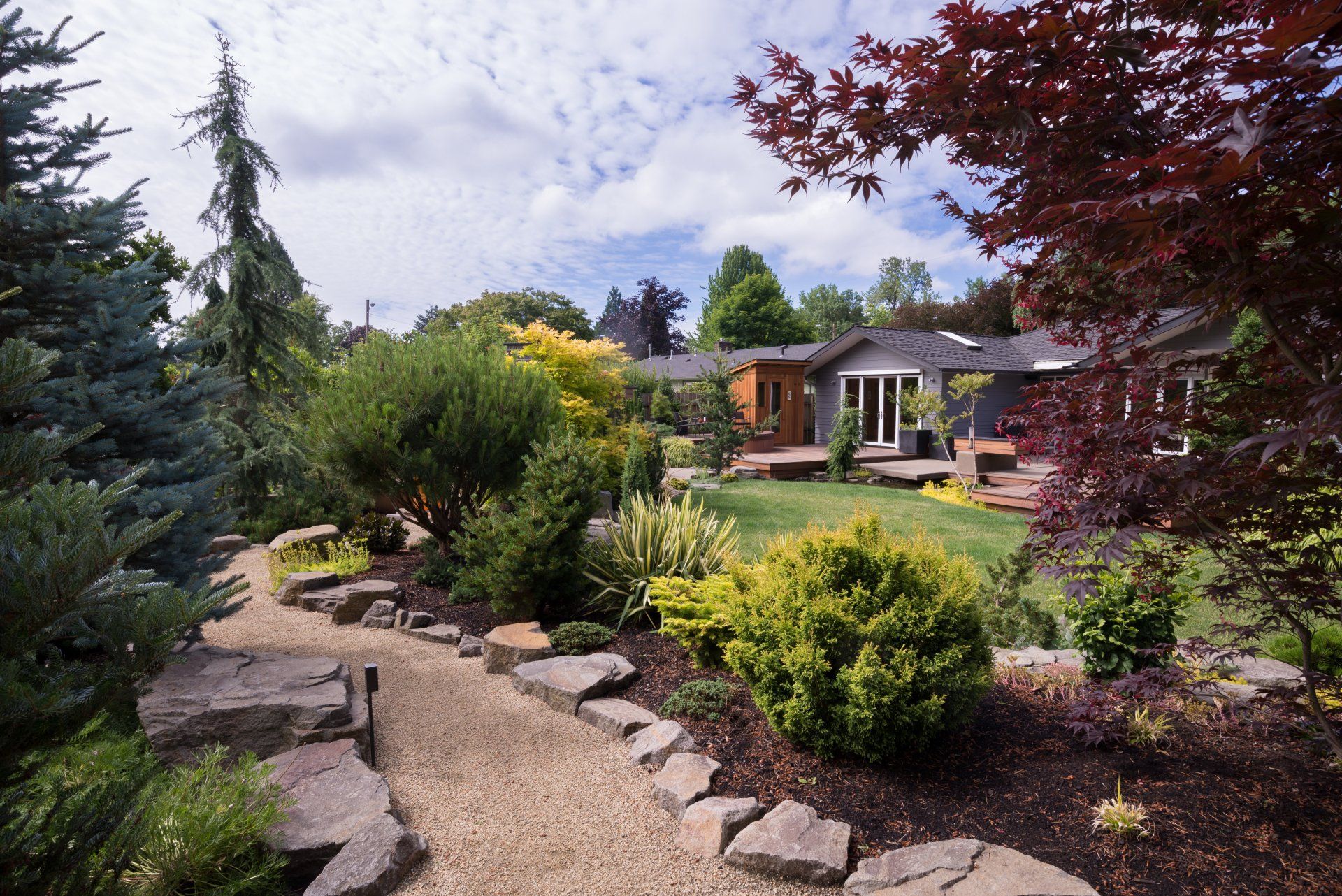 Un jardin verdoyant avec une maison en arrière-plan
