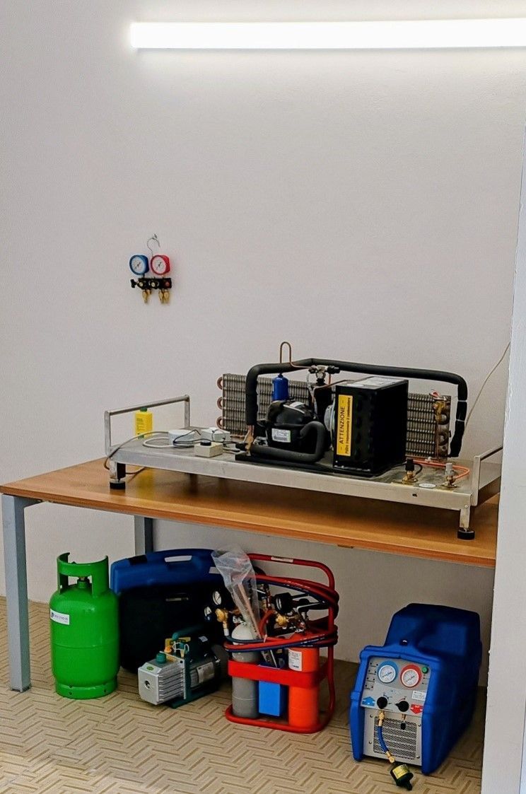 Banco da lavoro con macchinario industriale e bombole di gas in un garage o officina