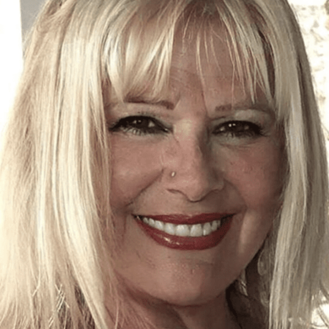 Smiling blonde woman with bangs and red lipstick, close-up portrait