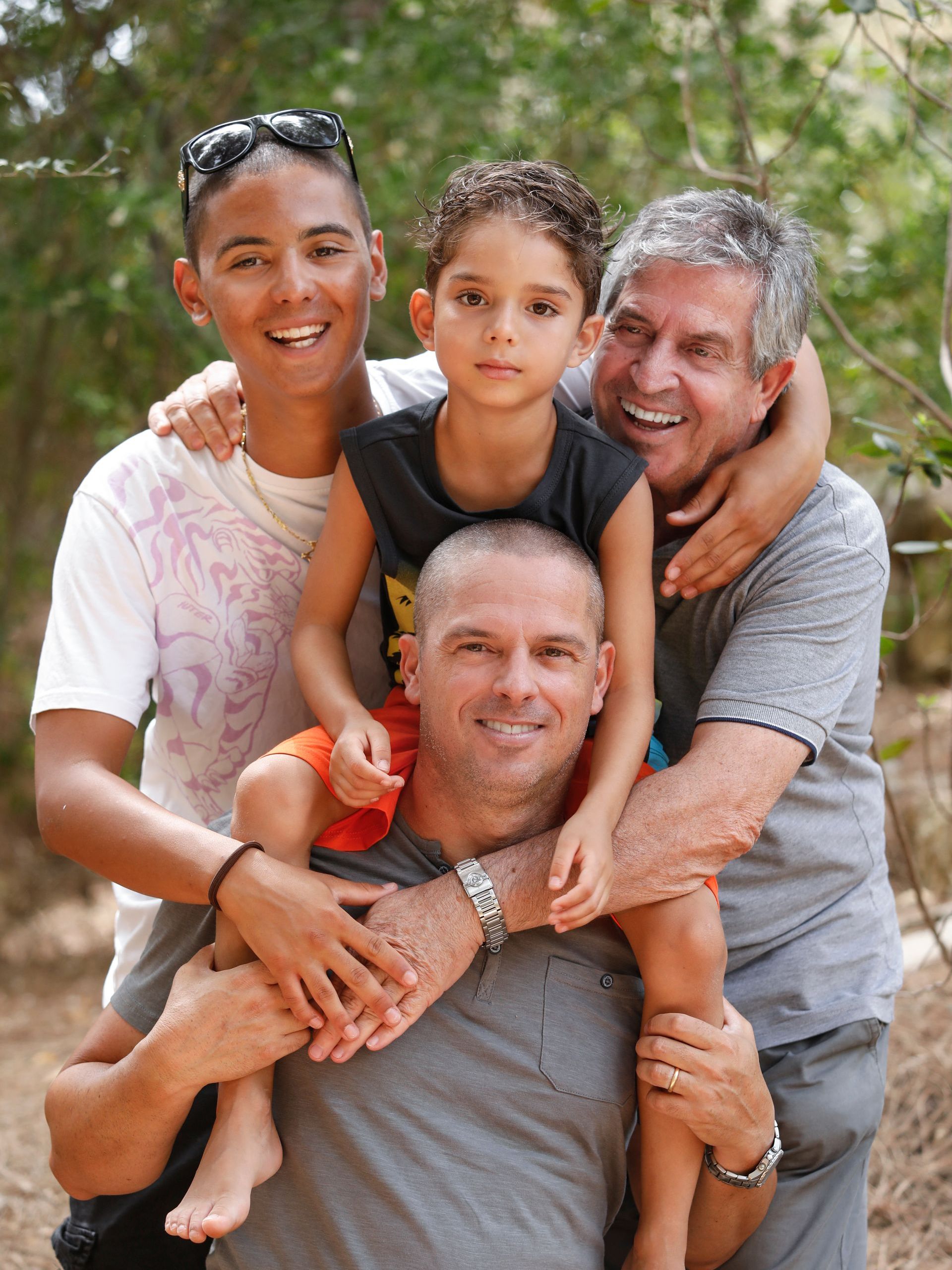 A man is carrying two children on his shoulders.