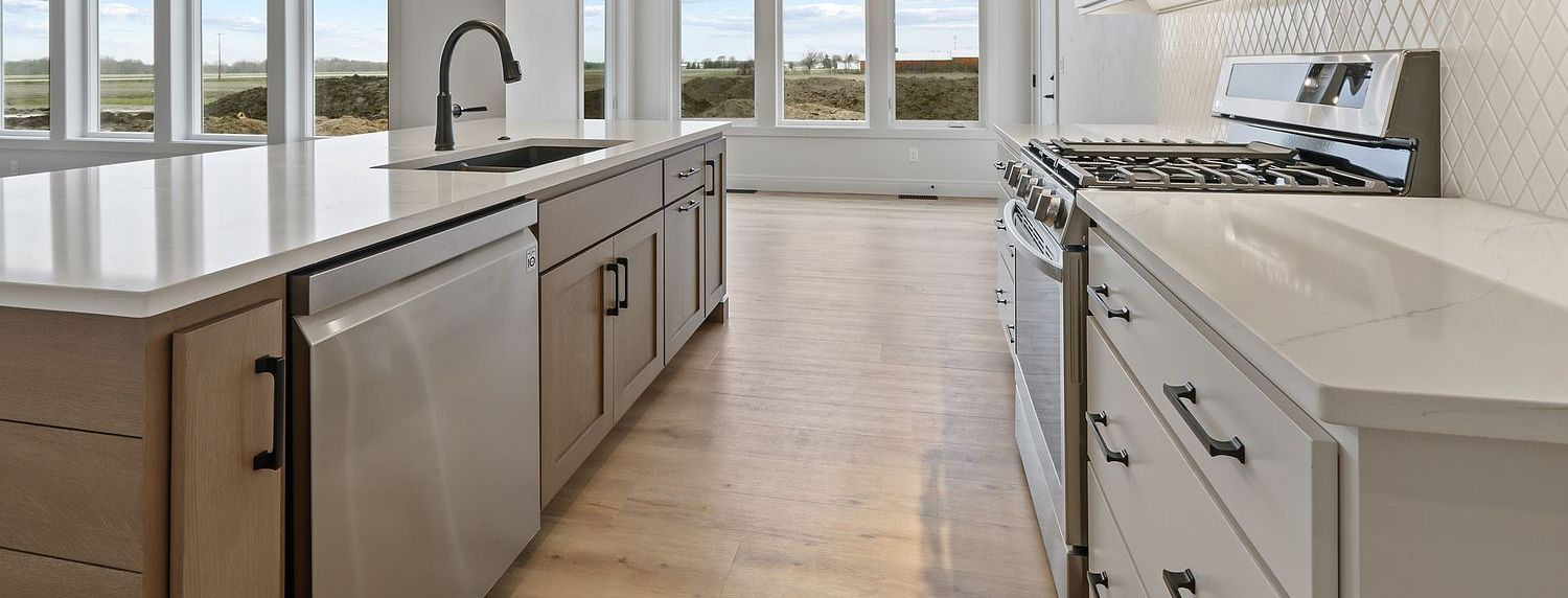 A kitchen with stainless steel appliances , white cabinets , and a large island.