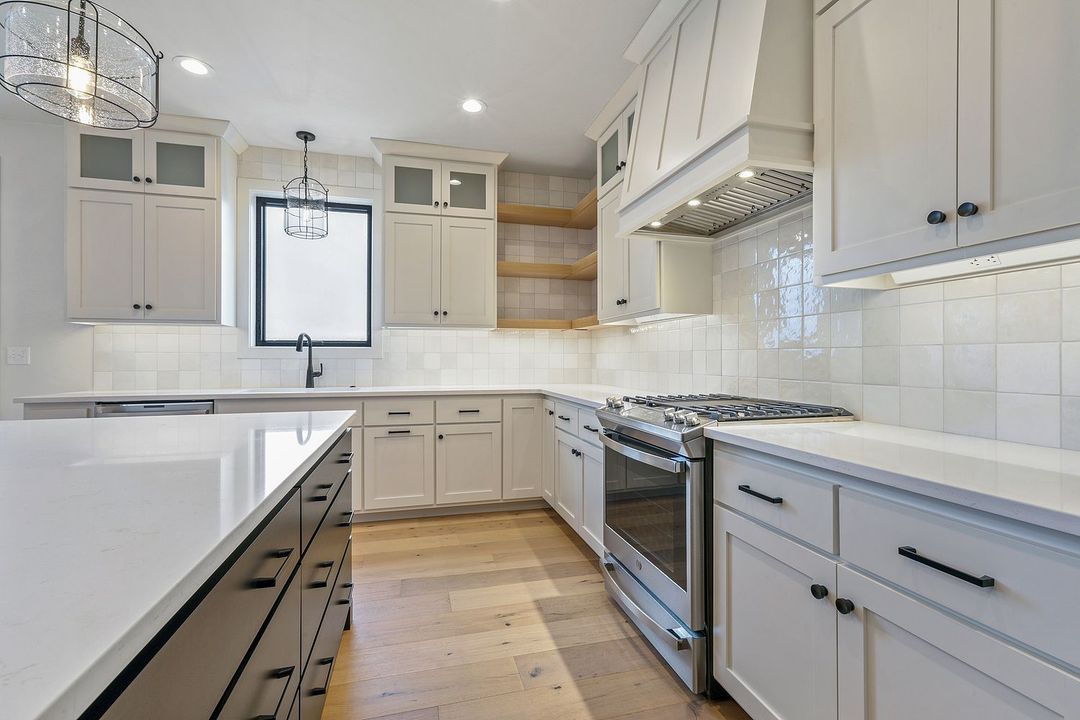 A kitchen with white cabinets and stainless steel appliances.