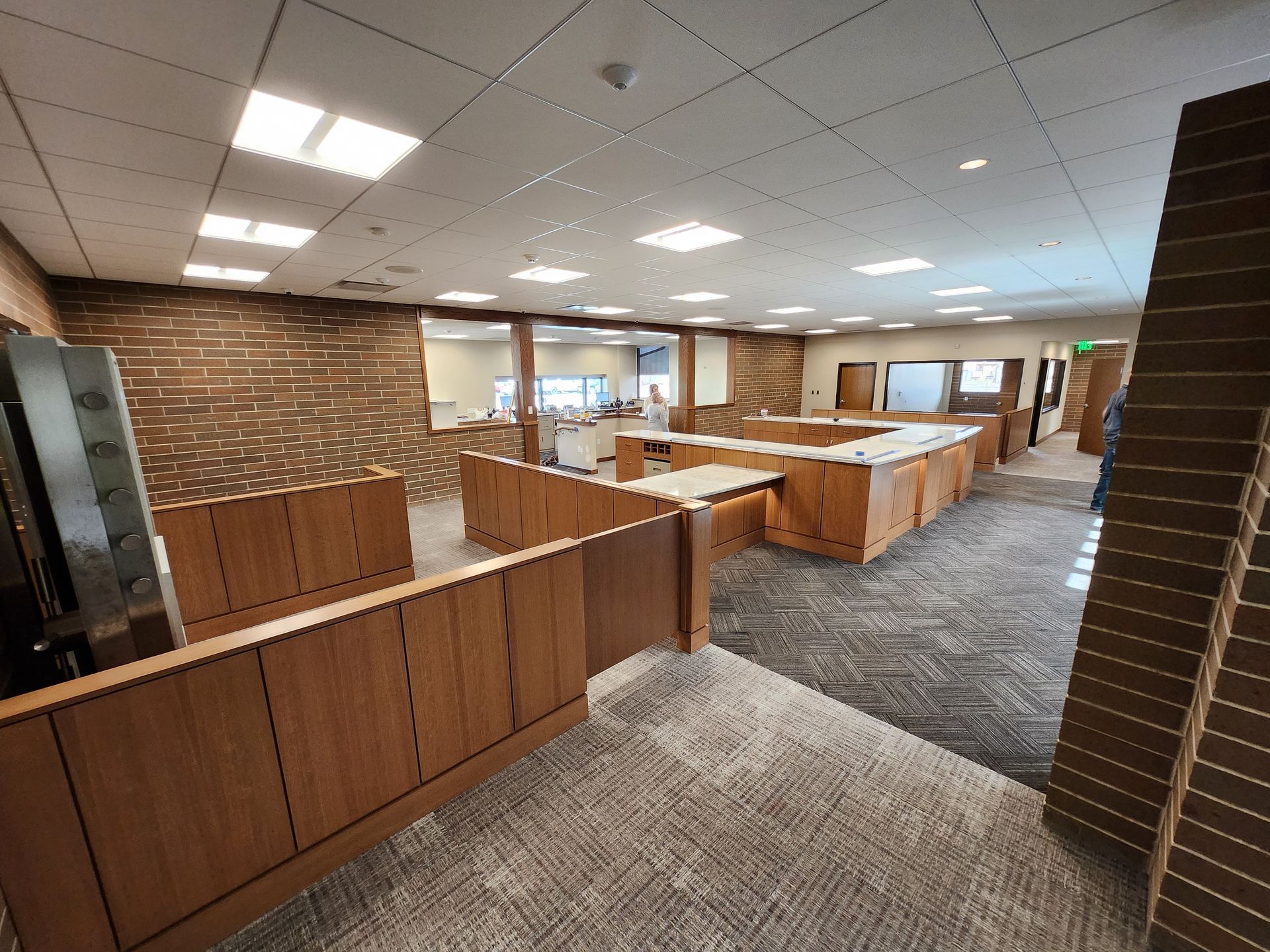 Office interior with wood paneling, desks, and a patterned carpet.