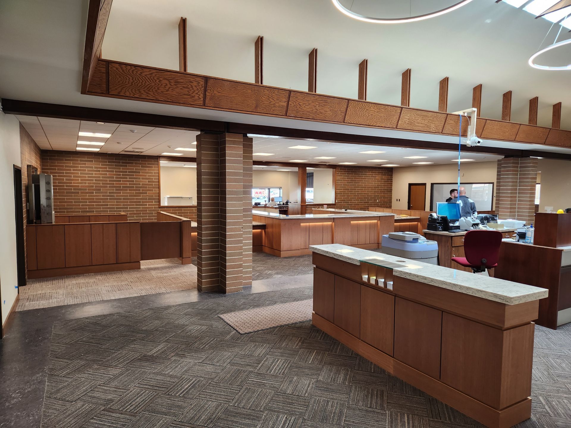 An open bank interior with multiple teller stations and dark wood accents.