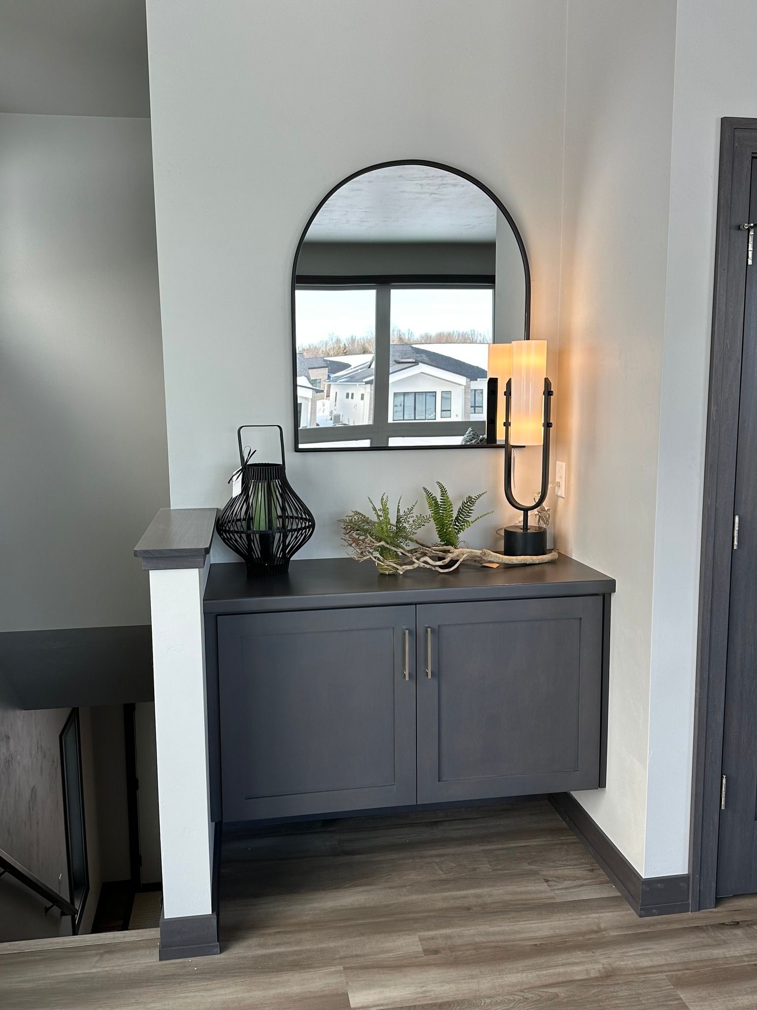A corner of a room with a dresser and a mirror.