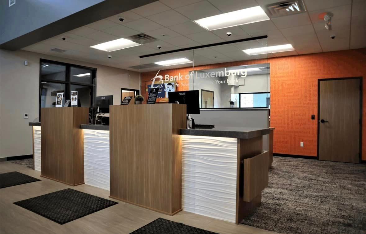 A bank lobby with a wooden counter and a white counter.
