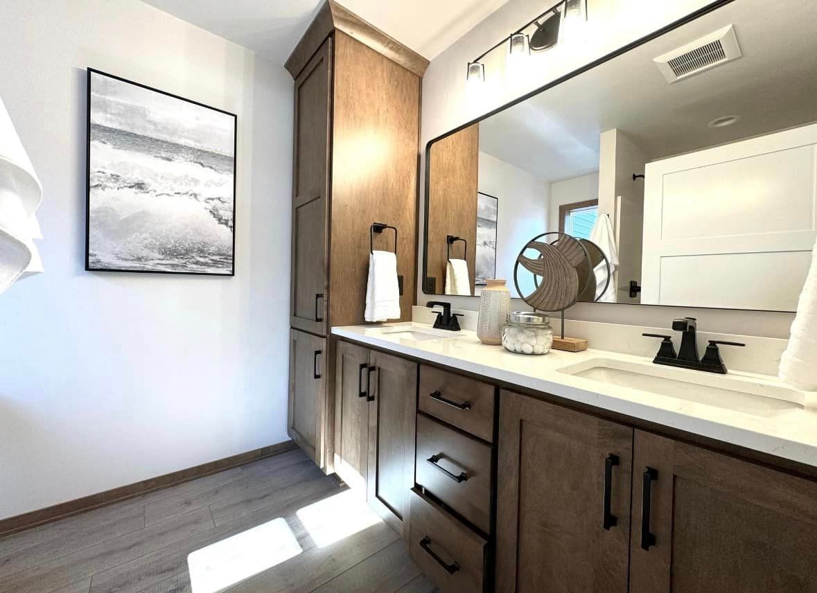 A bathroom with two sinks and a large mirror.