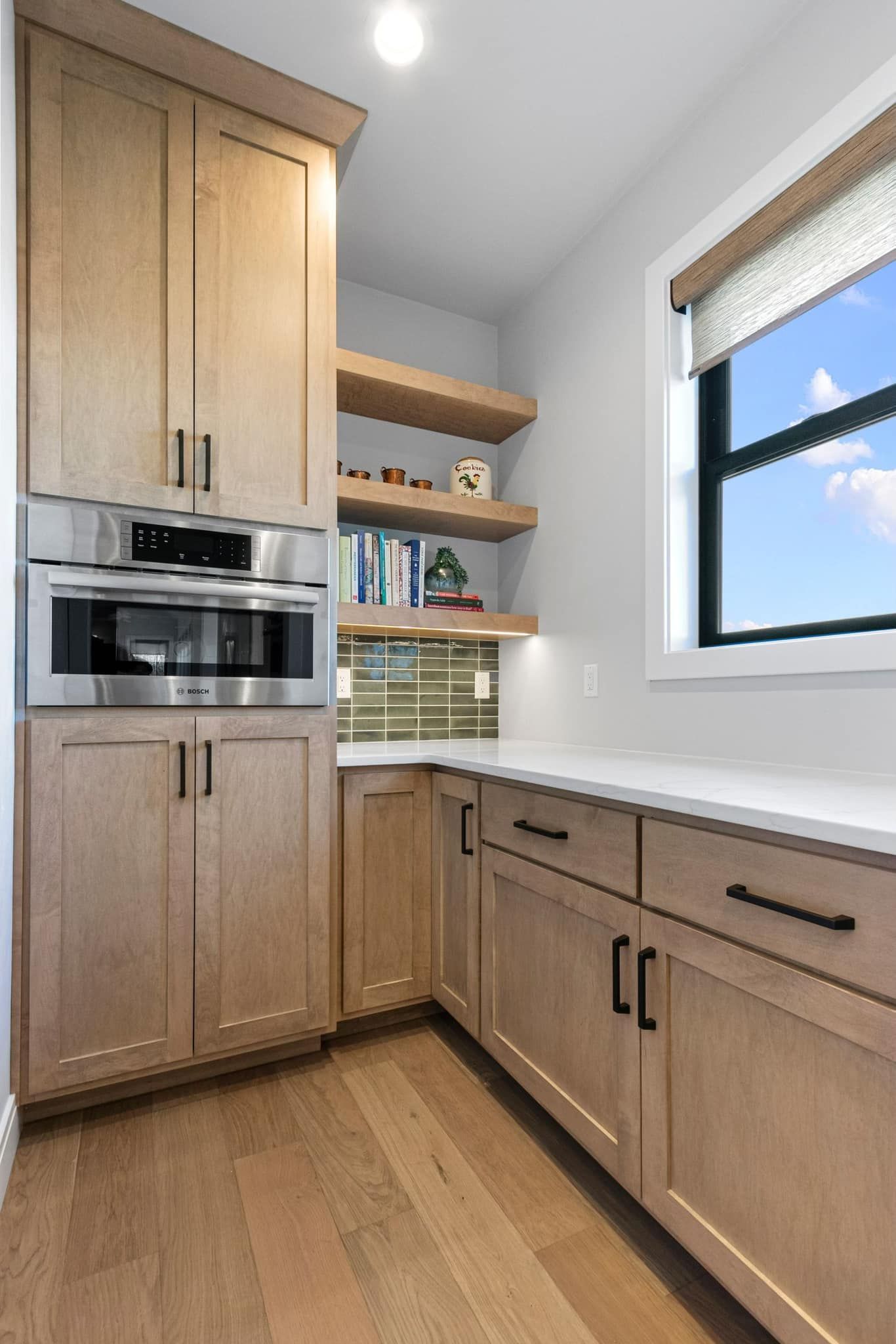 A kitchen with wooden cabinets , stainless steel appliances , and a window.