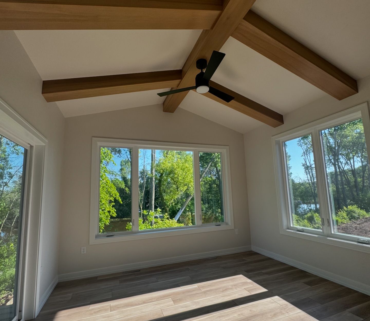 A room with a lot of windows and a ceiling fan