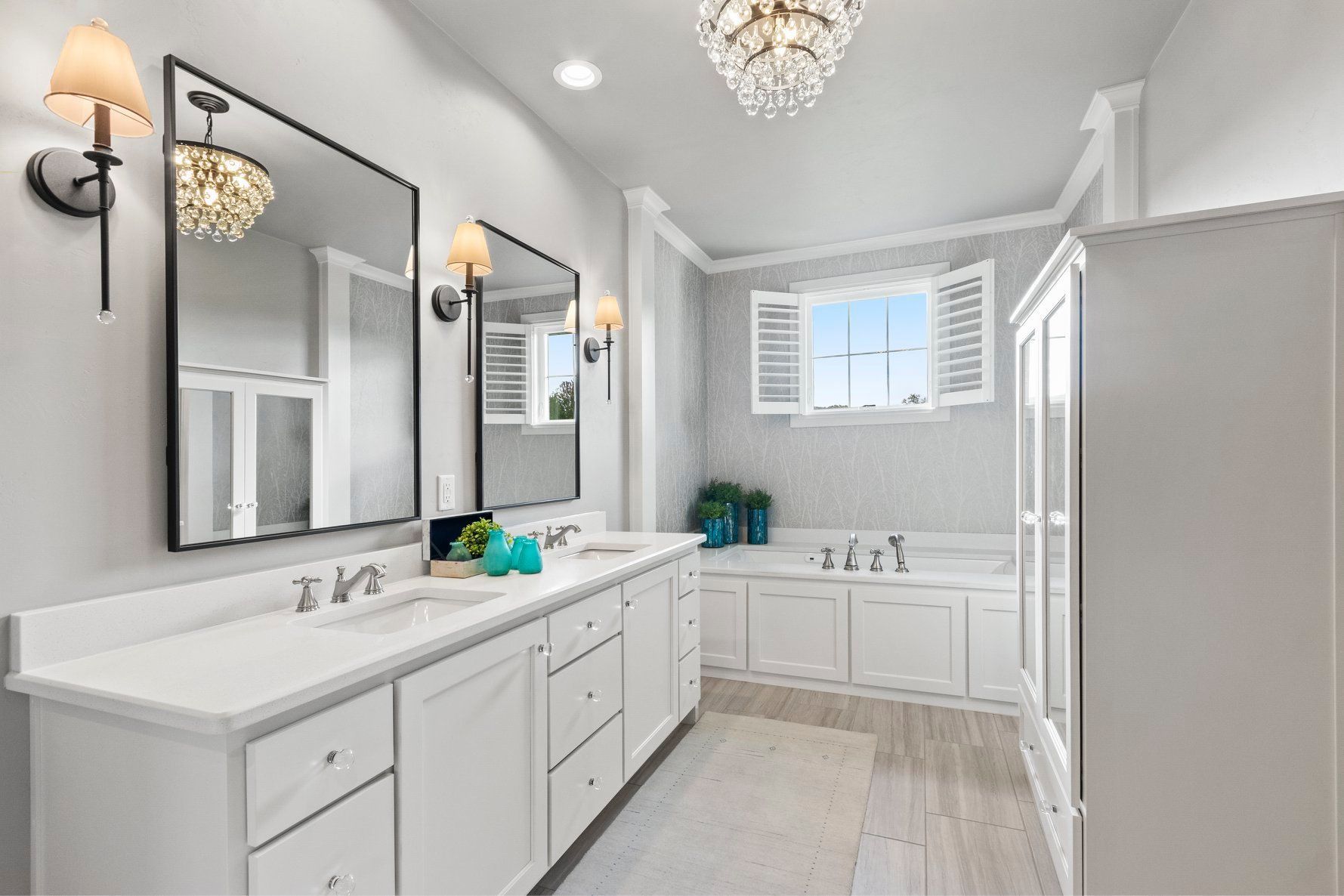 A bathroom with two sinks , two mirrors , a tub and a window.