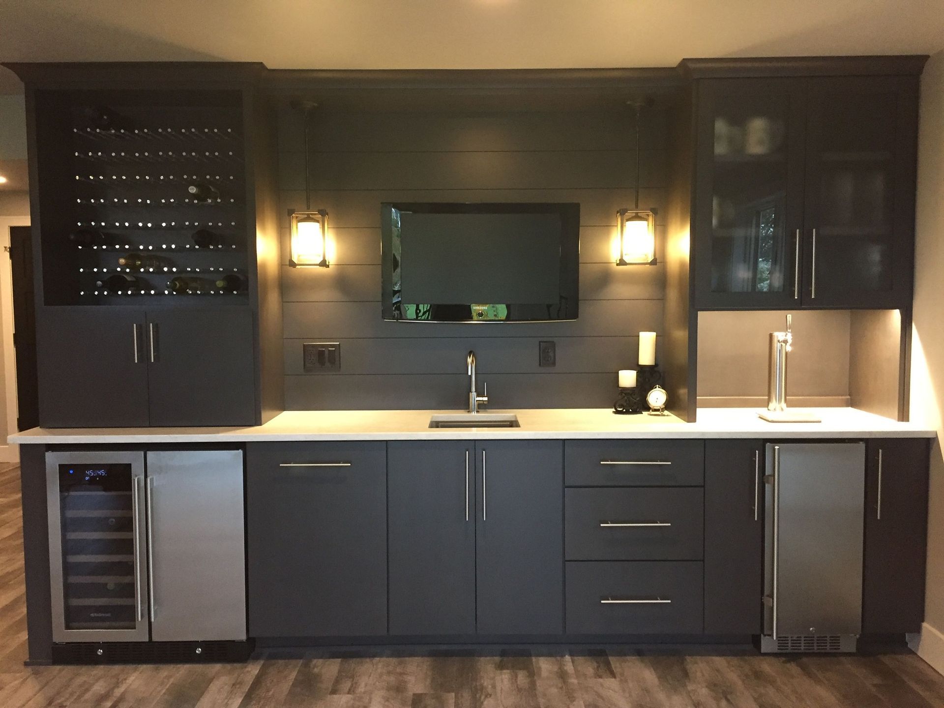 A kitchen with a sink and a television on the wall