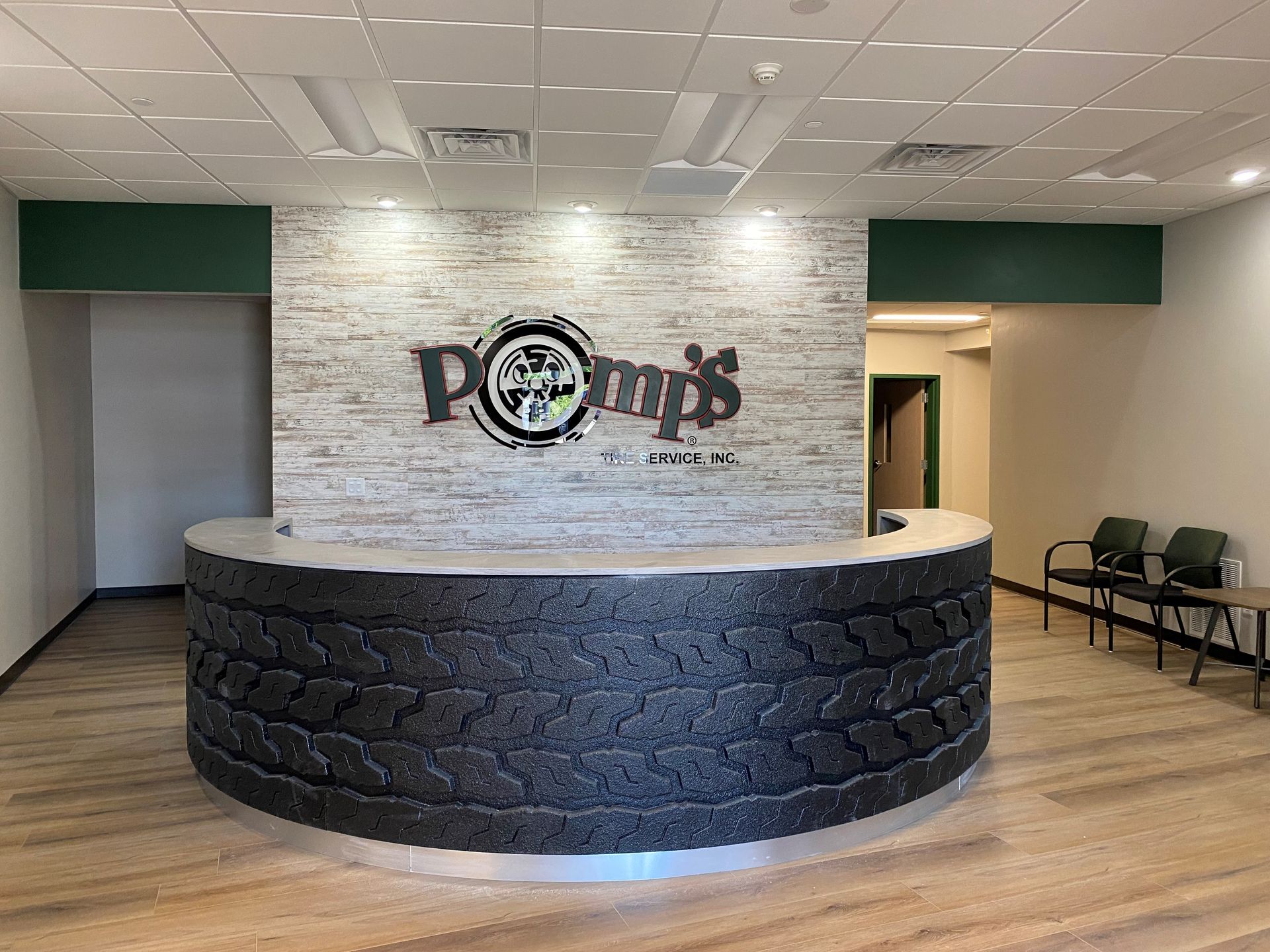 A reception area with a round counter and a brick wall.