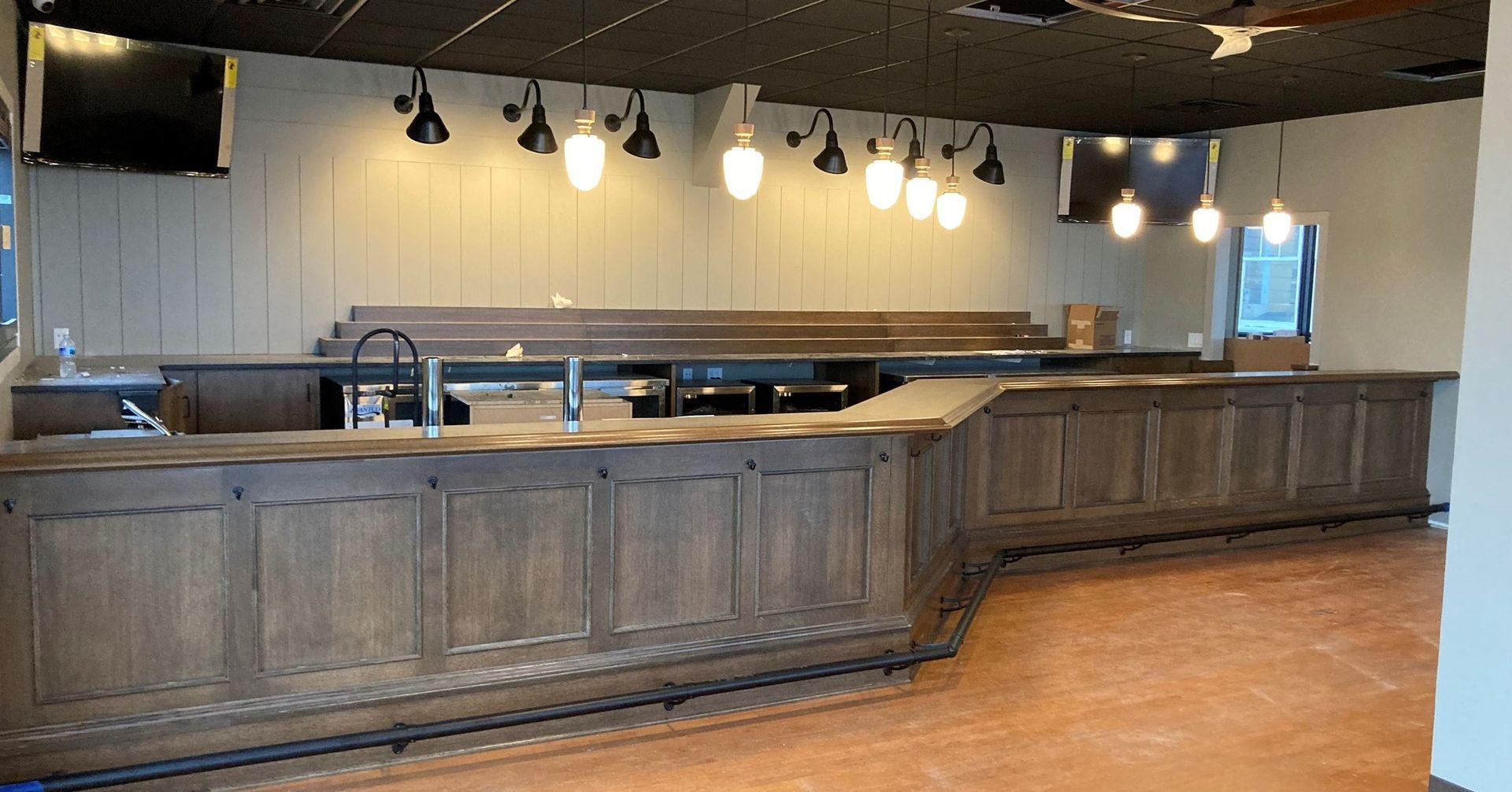 A large empty room with a long wooden bar.