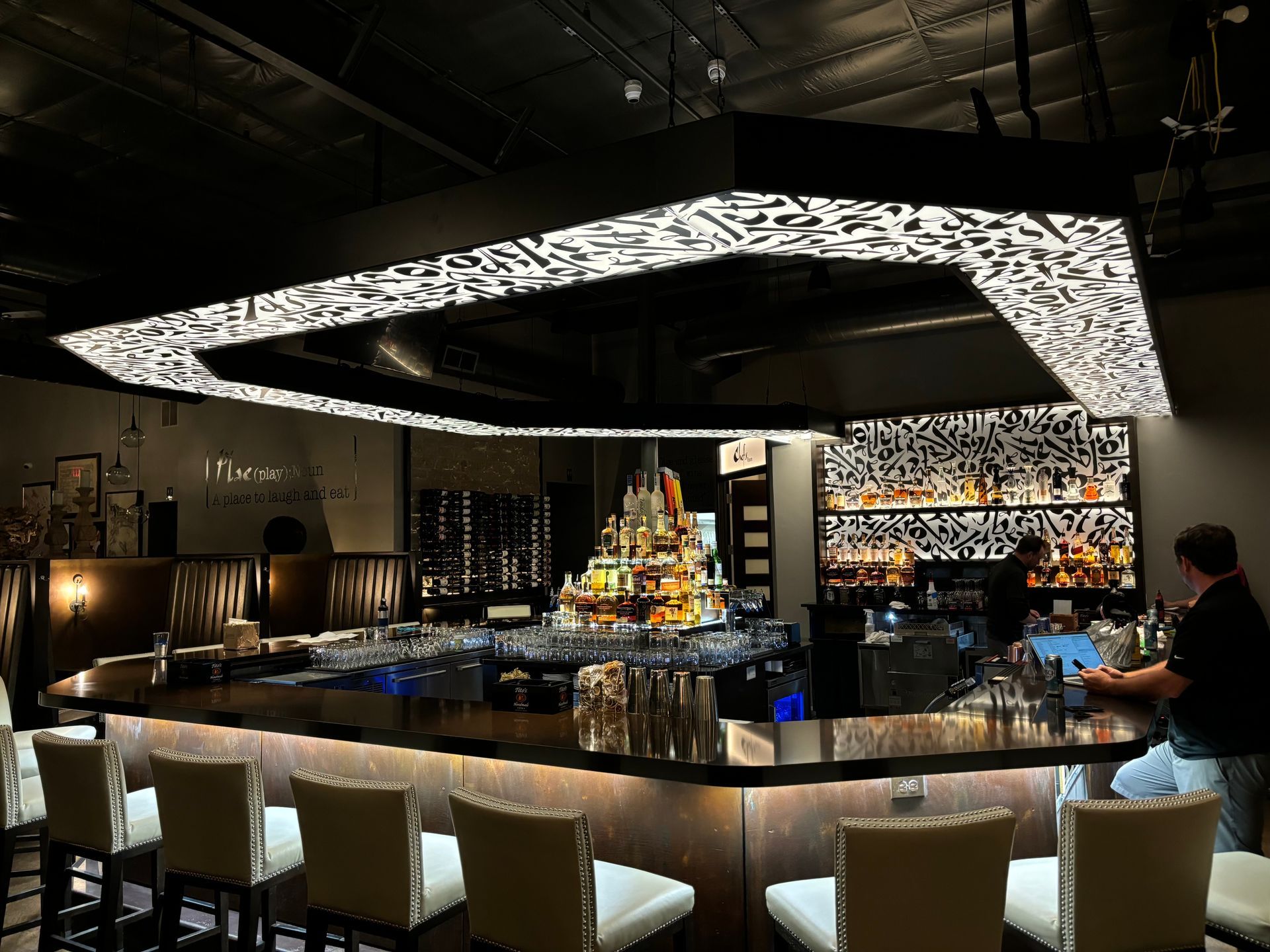 A man is standing at a bar in a restaurant