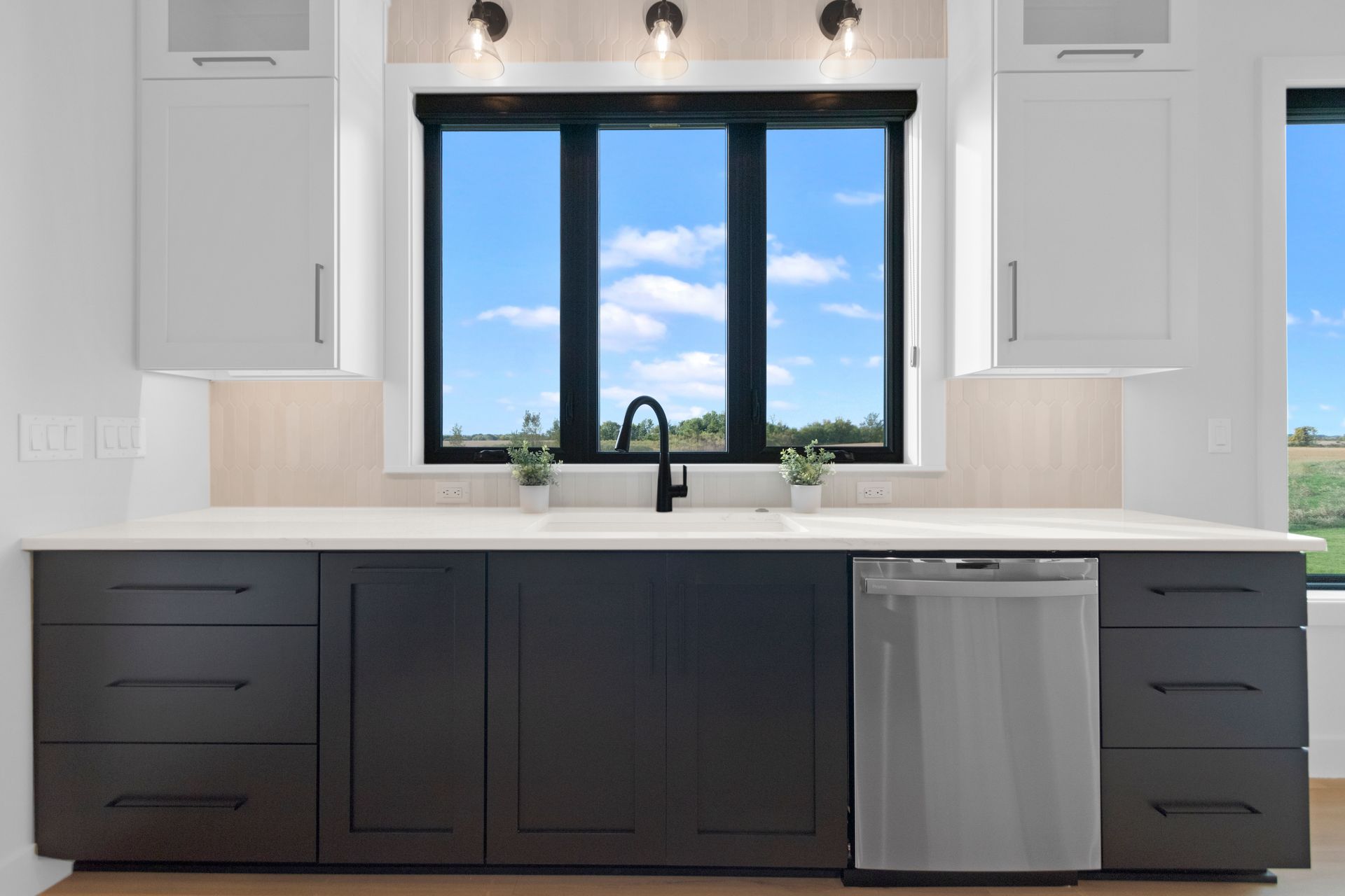 A kitchen with black cabinets and a stainless steel dishwasher