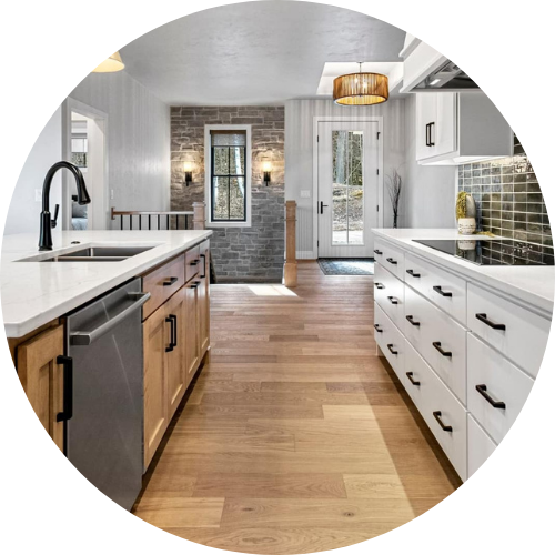 A kitchen with white cabinets and wooden floors in a circle.