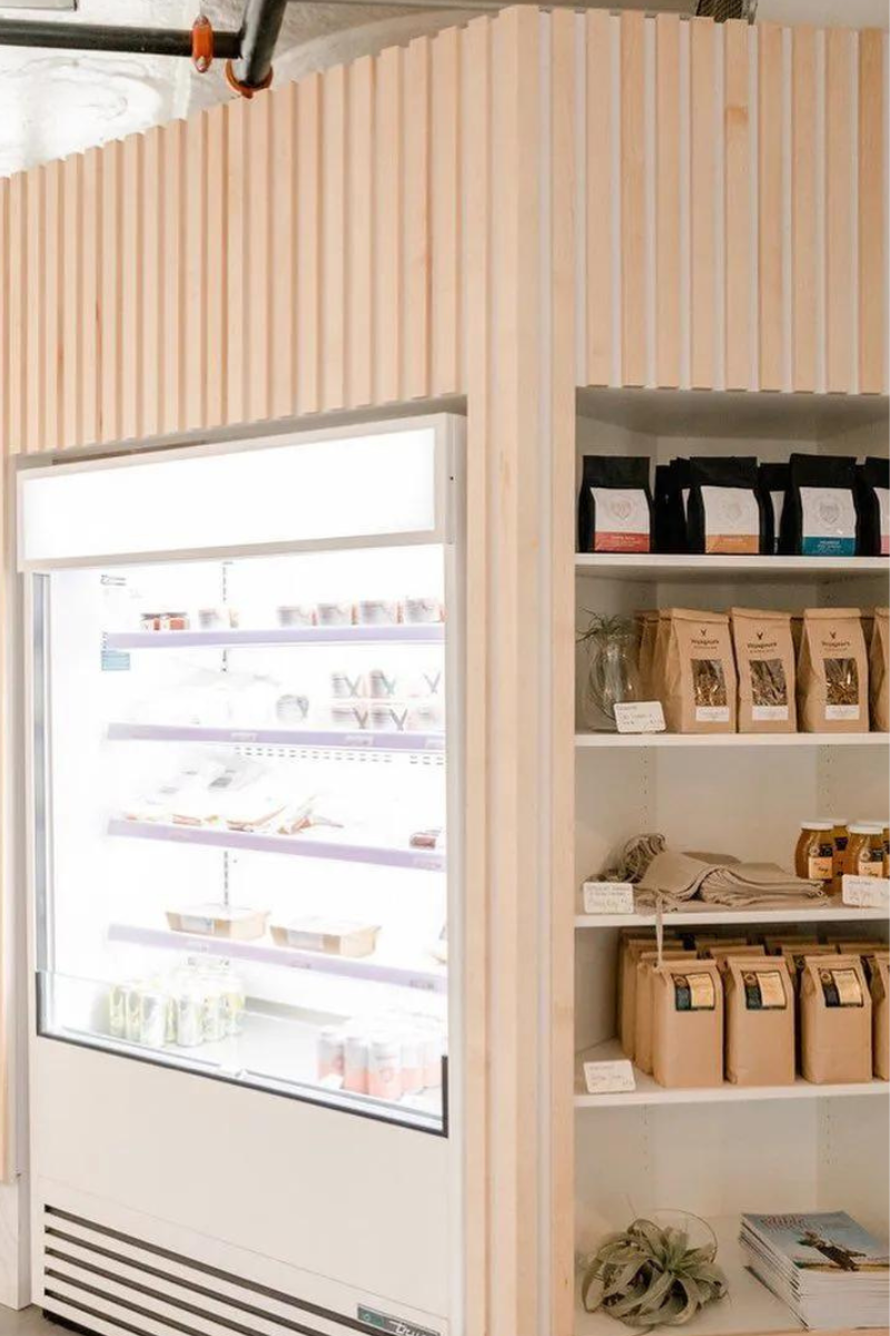 A store with a refrigerator and shelves filled with food.