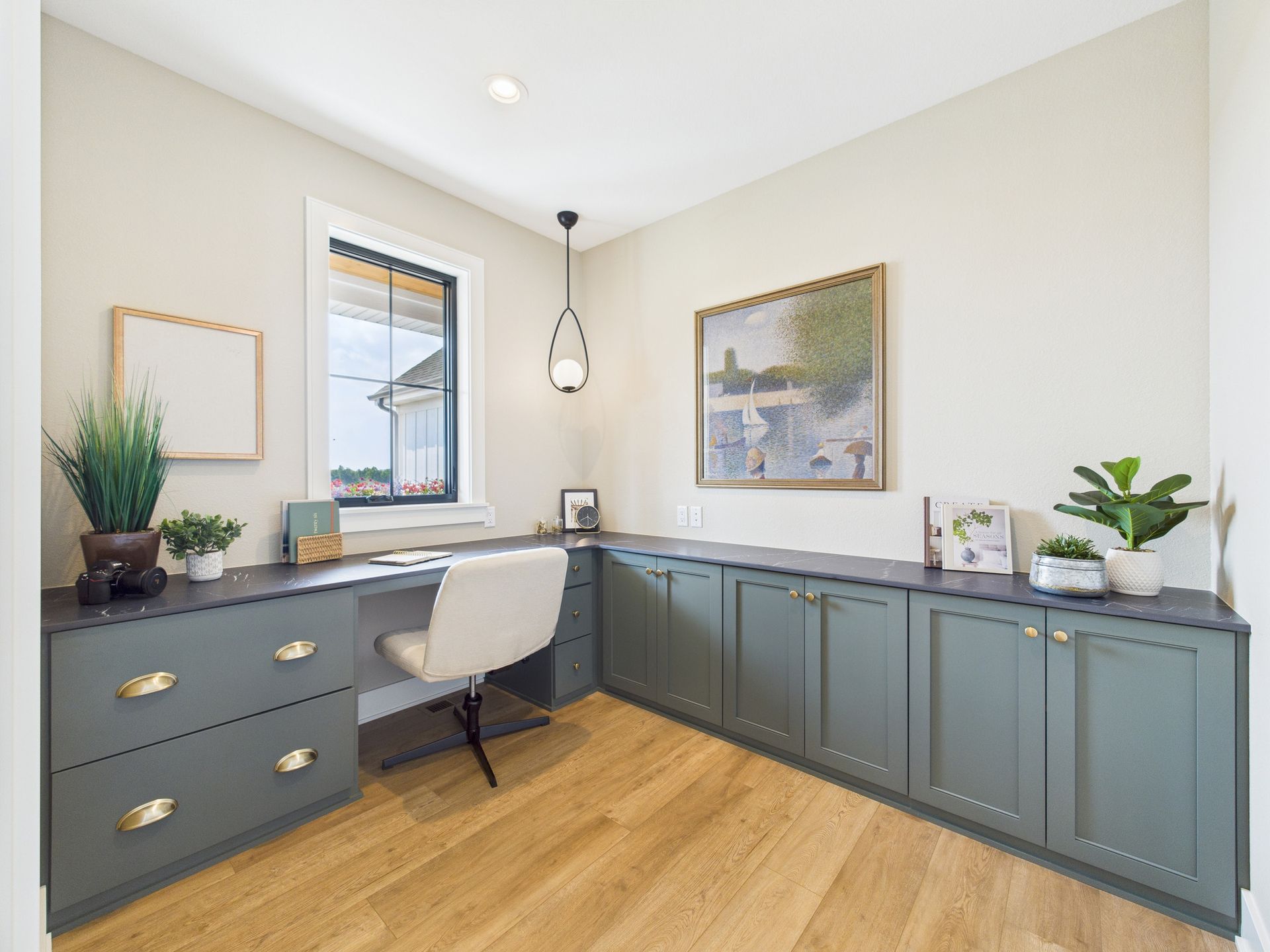 Home office with gray cabinets, wooden floor, and a desk with a white chair.