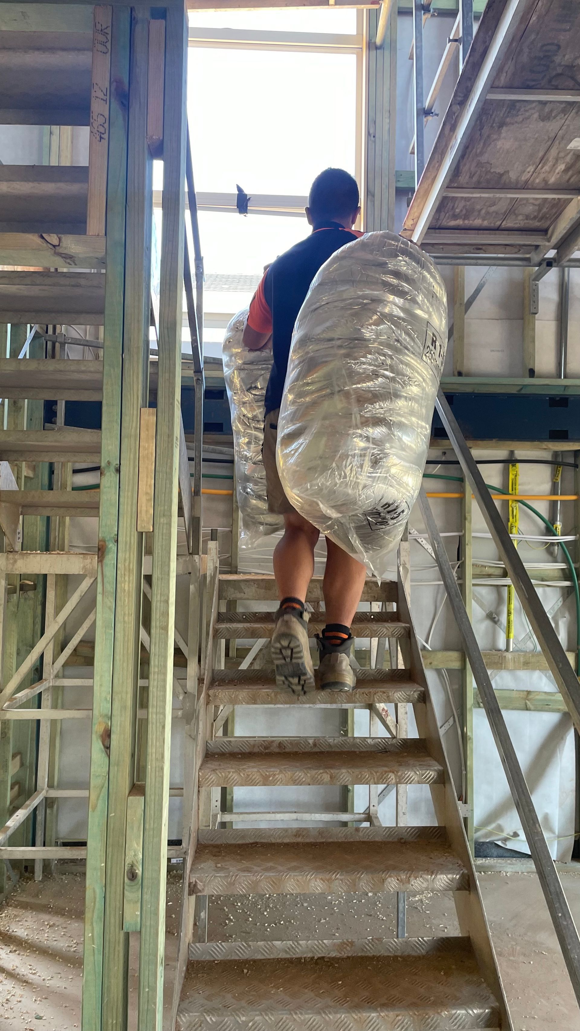 A man is carrying a large bag up a set of stairs.