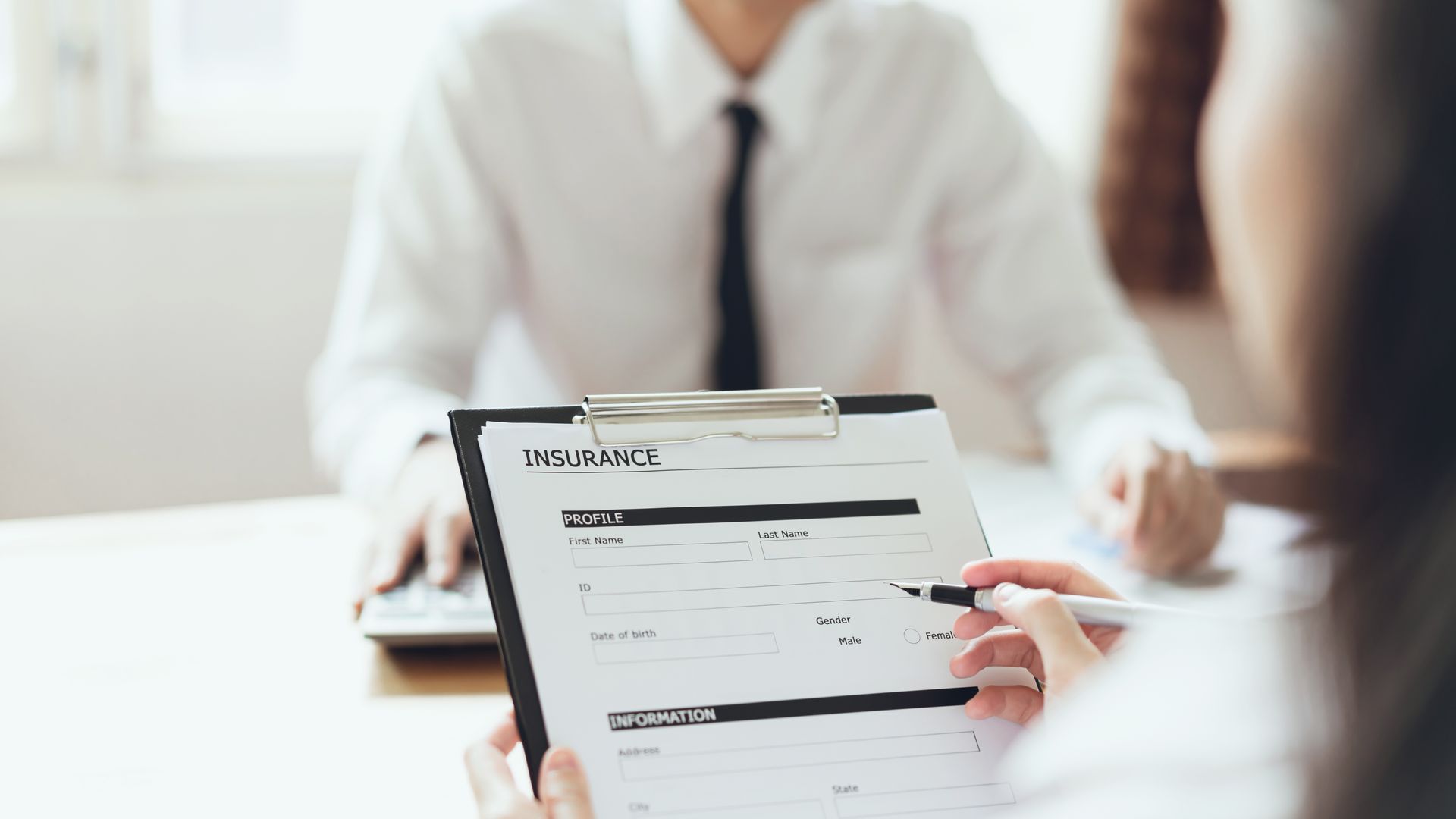 A businessman in the office fills out a medical insurance policy.