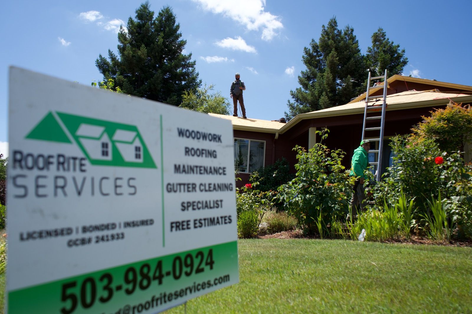 Sign for Roof Rite Services with a roofer on a roof in front of a house.