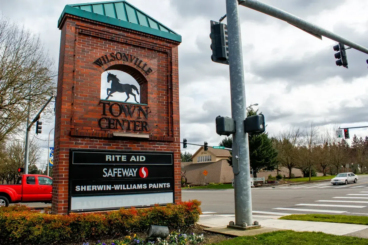 Wilsonville Town Center sign with brickwork and a horse silhouette; includes Rite Aid, Safeway, and Sherwin-Williams.