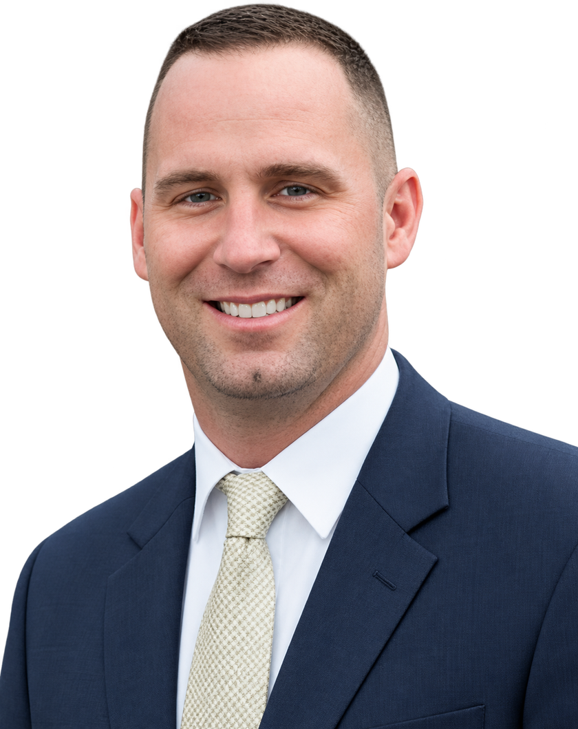 Smiling man in a navy suit, white shirt, and light tie against a white background