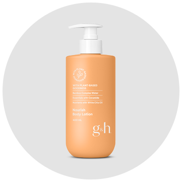 A bottle of gh body lotion is sitting on a white surface.
