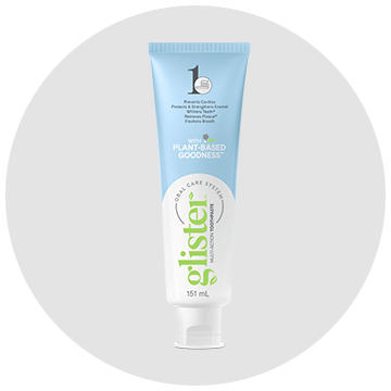 A tube of glister toothpaste is sitting on a white surface.