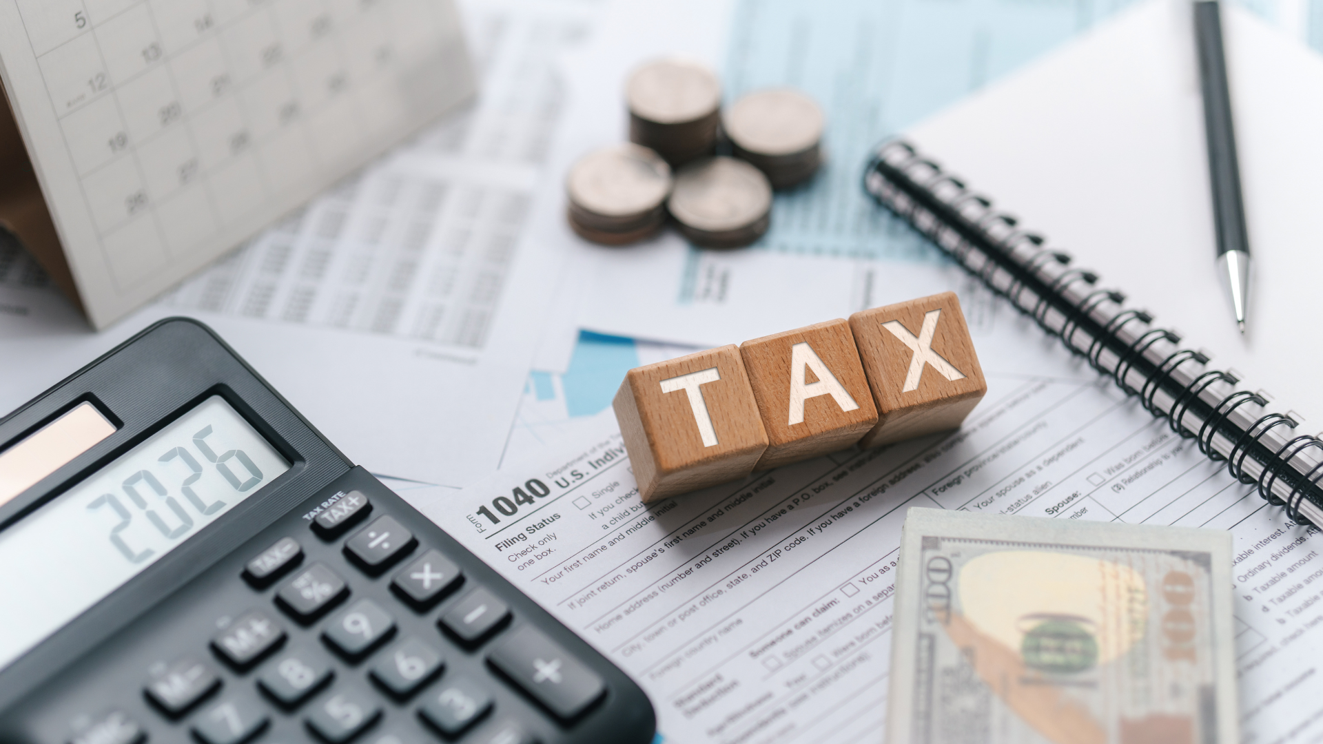 Close-up of a tax preparation scene showing wooden blocks spelling 
