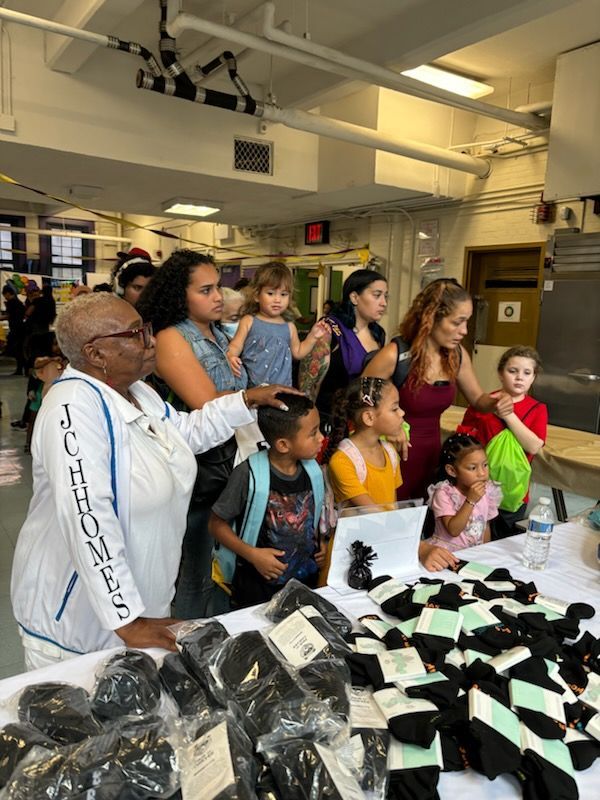 A group of people are standing around a table looking at socks.
