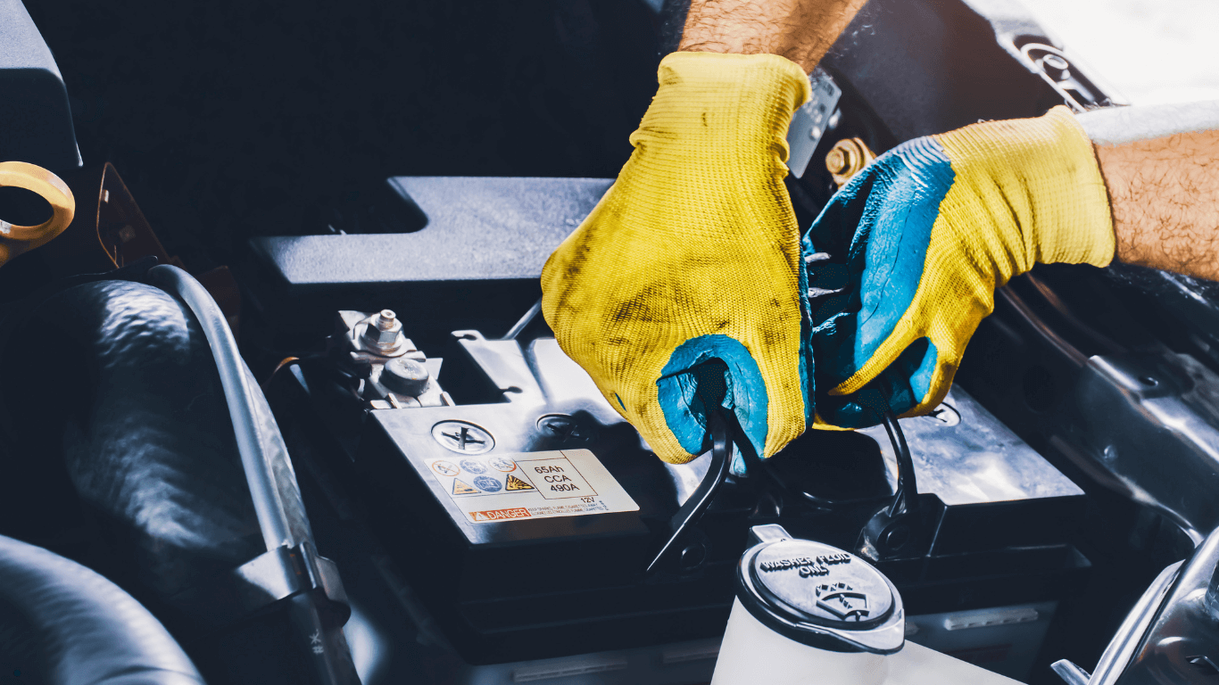 A mechanic working under the hood of a car