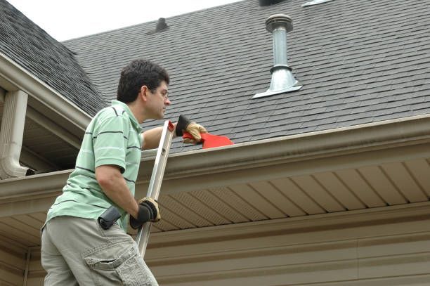 Close-up of specialized brush cleaning white gutter debris.