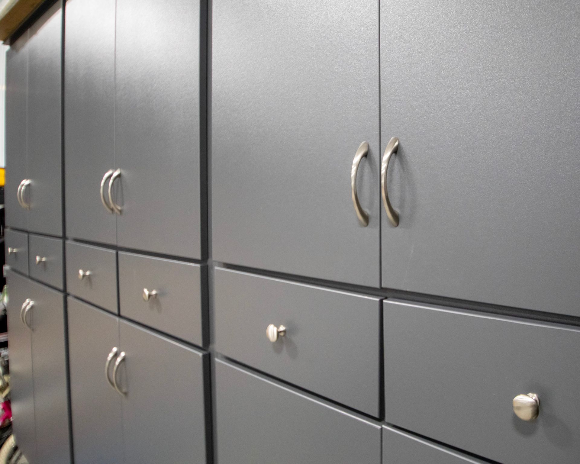 Gray filing cabinets with metal handles in an office corridor.