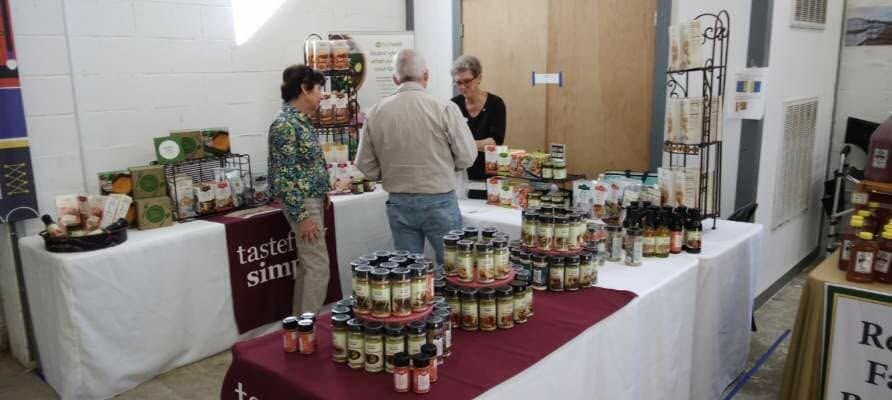 Vendor booth with jars of homemade jam and preserves on display at an indoor market