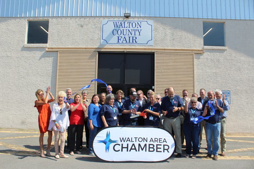 Group posing outside Walton County Fair with a Walton Area Chamber banner