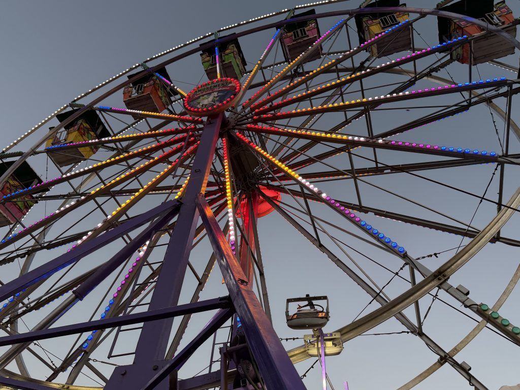 Ferris wheel with multicolored lights against a dusk sky