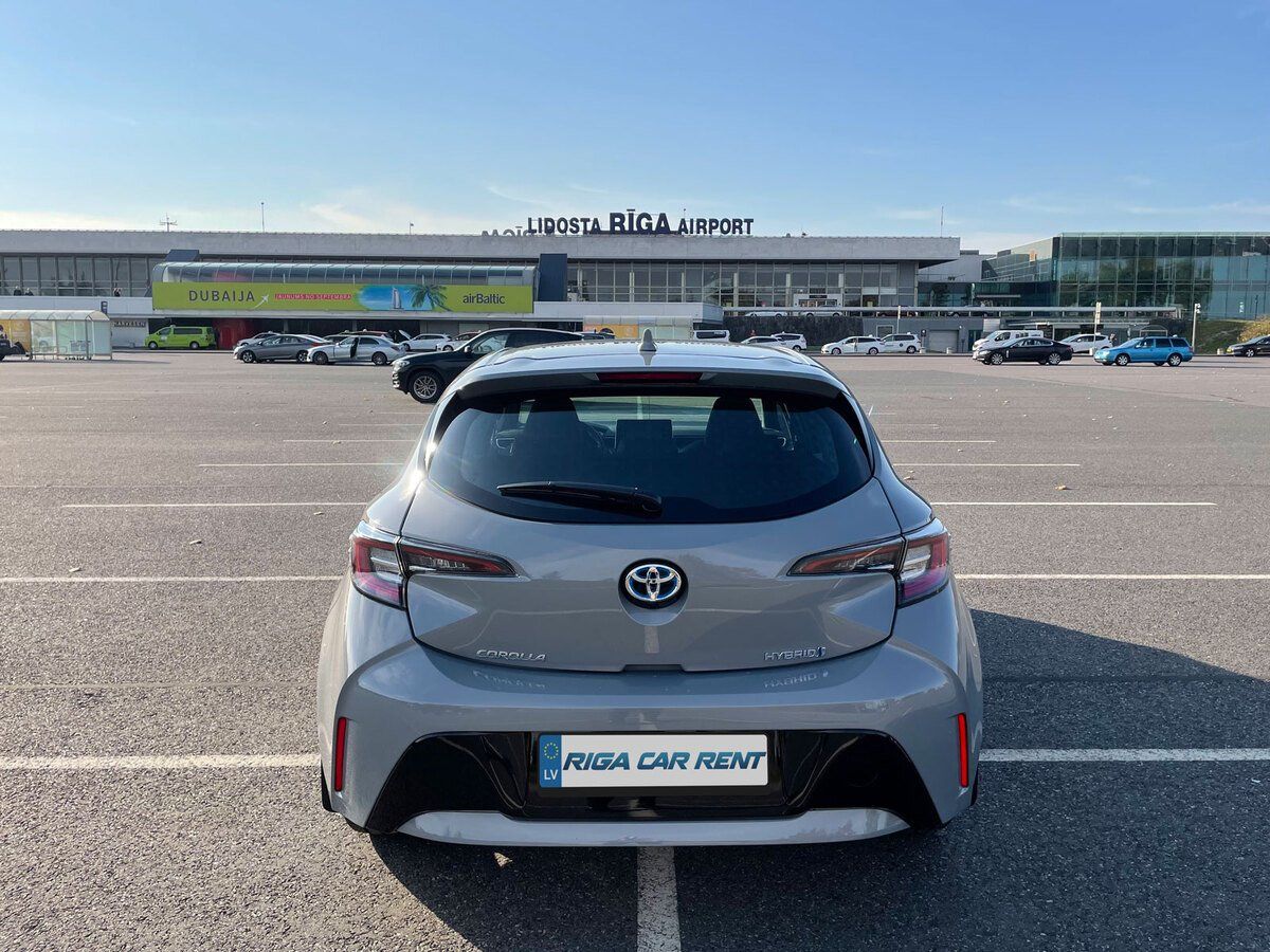 Sudraba krāsas Toyota Corolla aizmugure ir novietota stāvvietā.