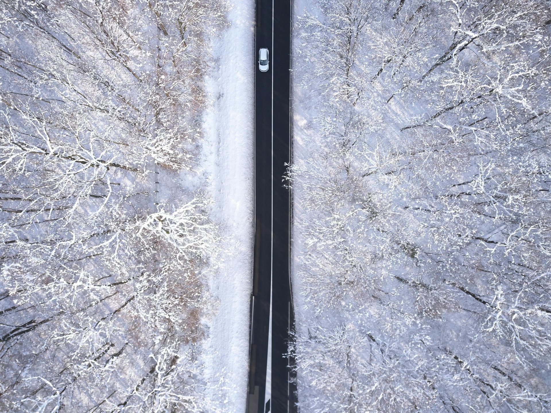 Auto uz šosejas, kur apkārt ir sniegs
