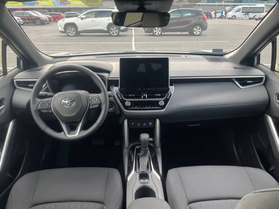 Autostāvvietā ir parādīts Toyota Corolla Cross salons.