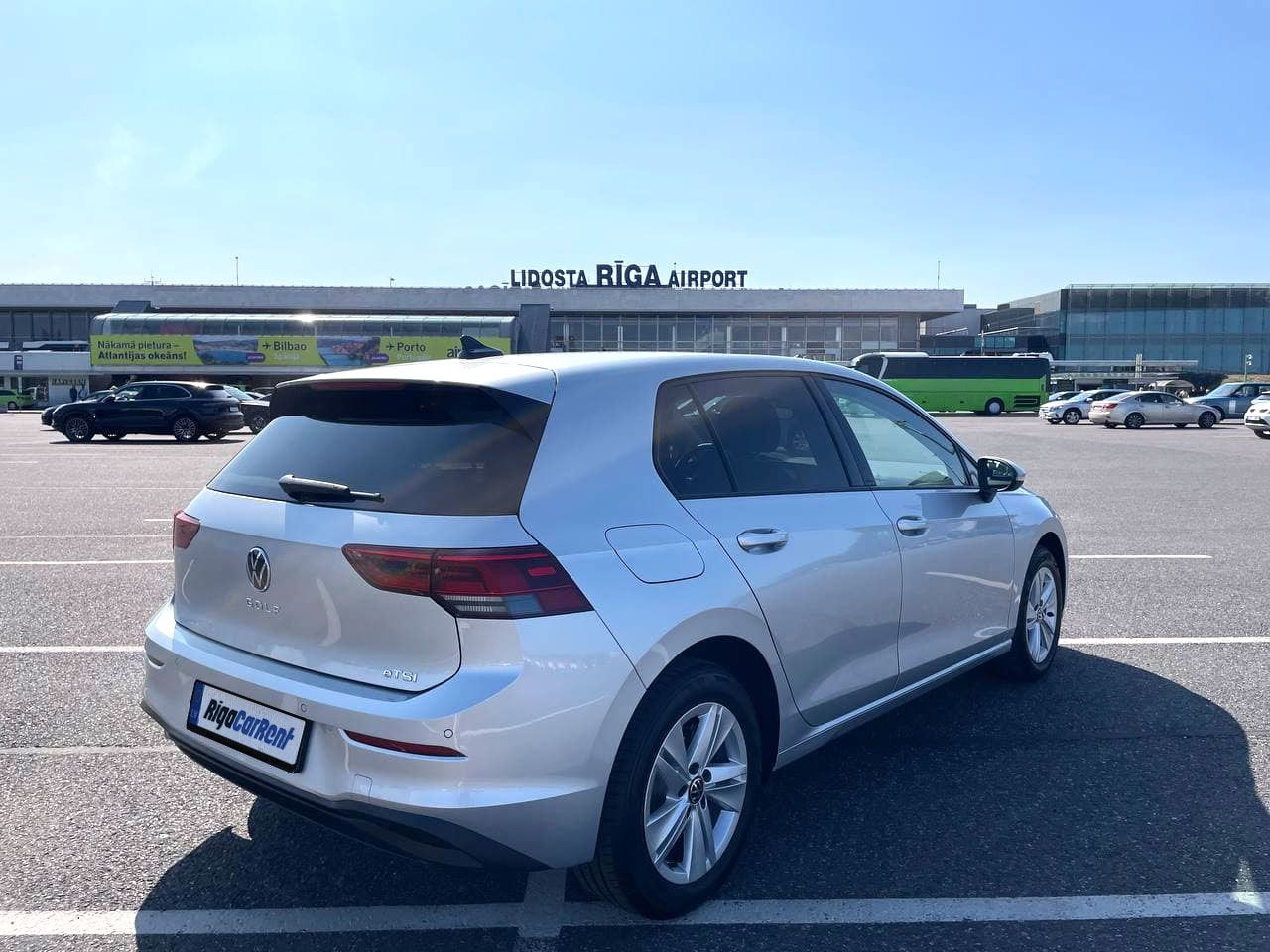 Autostāvvietā ir novietots sudrabains Volkswagen Golf.