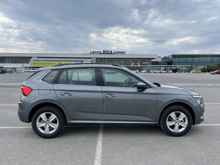 Skoda Kamiq ir novietota autostāvvietā lidostas priekšā.